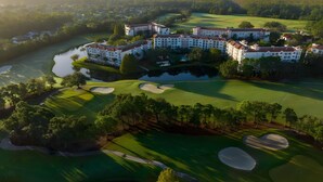Vue aérienne d’un terrain de golf avec un grand complexe hôtelier.