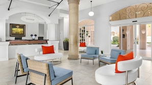 Un espace d’accueil moderne comprenant un comptoir de réception, un coin salon et une grande colonne.