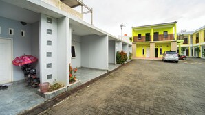 A residential building with a covered entrance and a parked car in the driveway. - Hotel D2 By ARBA (Weleri)