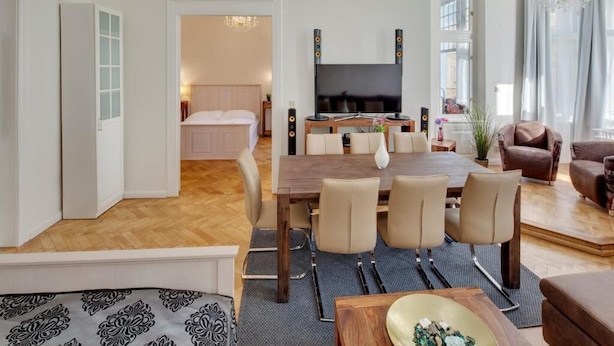Een moderne woonkamer met een eethoek, een televisie en een gezellige zithoek.