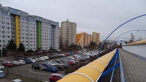 Een parkeerplaats met meerdere auto's en een gele constructie.
