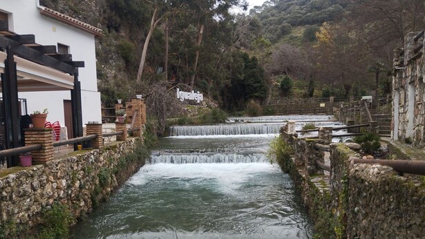 A river with multiple waterfalls, stone walls, and a building with a pergola and potted plants. - Holiday Home 'Alojamiento Patricia' with Mountain Views, Private Terrace and Wi-Fi (Igualeja)