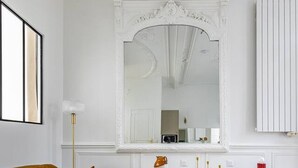 Ett modernt vardagsrum med en soffa i senapsgul färg, ett rött soffbord och en vit konsol med dekorativa föremål.