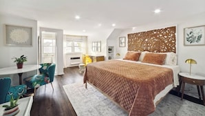 Een moderne slaapkamer met een groot bed, een bureau en een stoel.