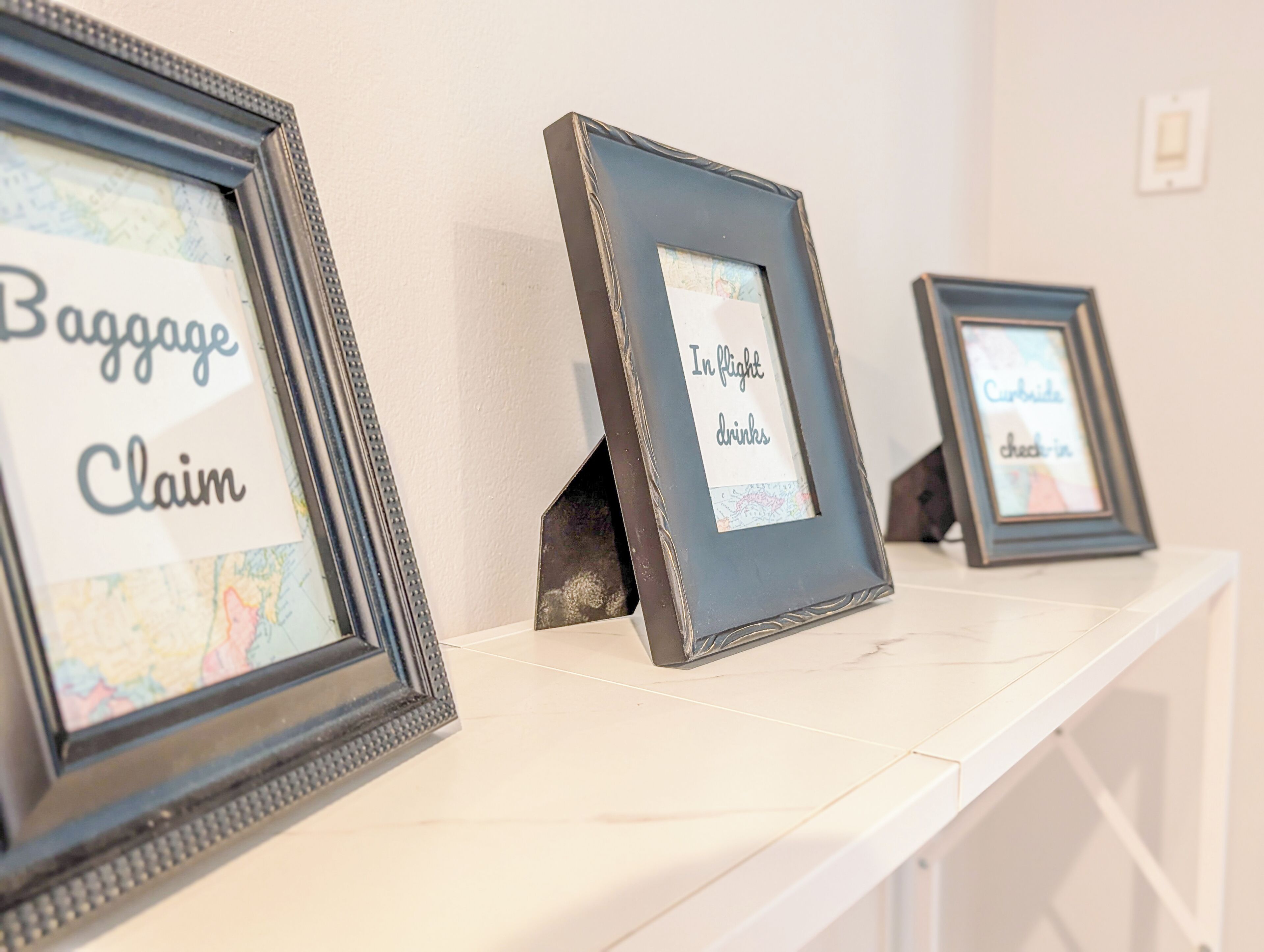 A wall with three framed items, each with a label.