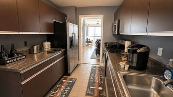 A modern kitchen with stainless steel appliances, a built-in oven, and a large sink.