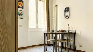 Un coin repas comprenant une table et des chaises, un radiateur et une horloge fixée au mur.