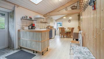 A cozy kitchen with a wooden countertop, a dining area with wicker chairs, and a view of the outdoors.