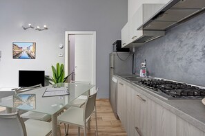 Una cucina moderna con piano cottura a gas, lavastoviglie e piccolo frigorifero.