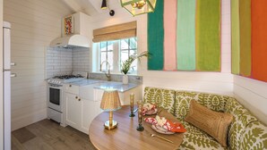 A kitchen with white cabinetry, a gas stove, and a dining area with a round table.