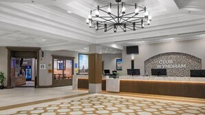 A hotel lobby with a reception desk, a large chandelier, and a patterned floor. - Wyndham 2-BR Deluxe Condo. Sleeps 8, June 20-27th.Ocean View, Full Kitchen (North Myrtle Beach)
