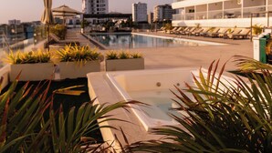A rooftop pool area with lounge chairs and potted plants. - Apartamento de lujo Cartagena Beach, Cartagena de indias -Colombia (Cartagena de Indias)