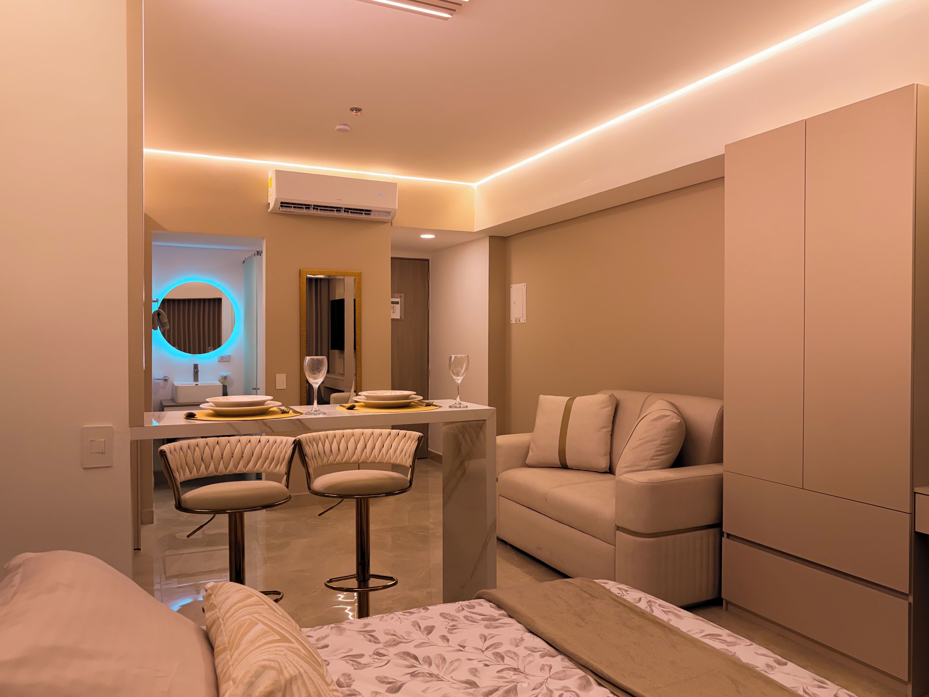 Une chambre d’hôtel moderne comprenant un coin repas, un canapé et un lit.