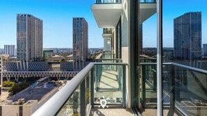 Un grattacielo con un balcone in vetro che si affaccia su un panorama urbano.