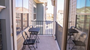 A balcony with a carpeted floor, two tables, and four chairs. - Escape to the heart of Colorado! (Loveland)