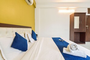 Ein Hotelzimmer mit einem Bett, einem Holzschrank und einer Wandklimaanlage.