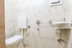 Ein Badezimmer mit Toilette, Waschbecken und Dusche.