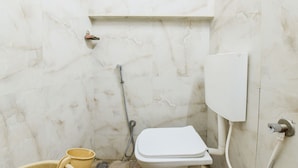 Pieni kylpyhuone, jossa on wc, suihku ja pesuallas.