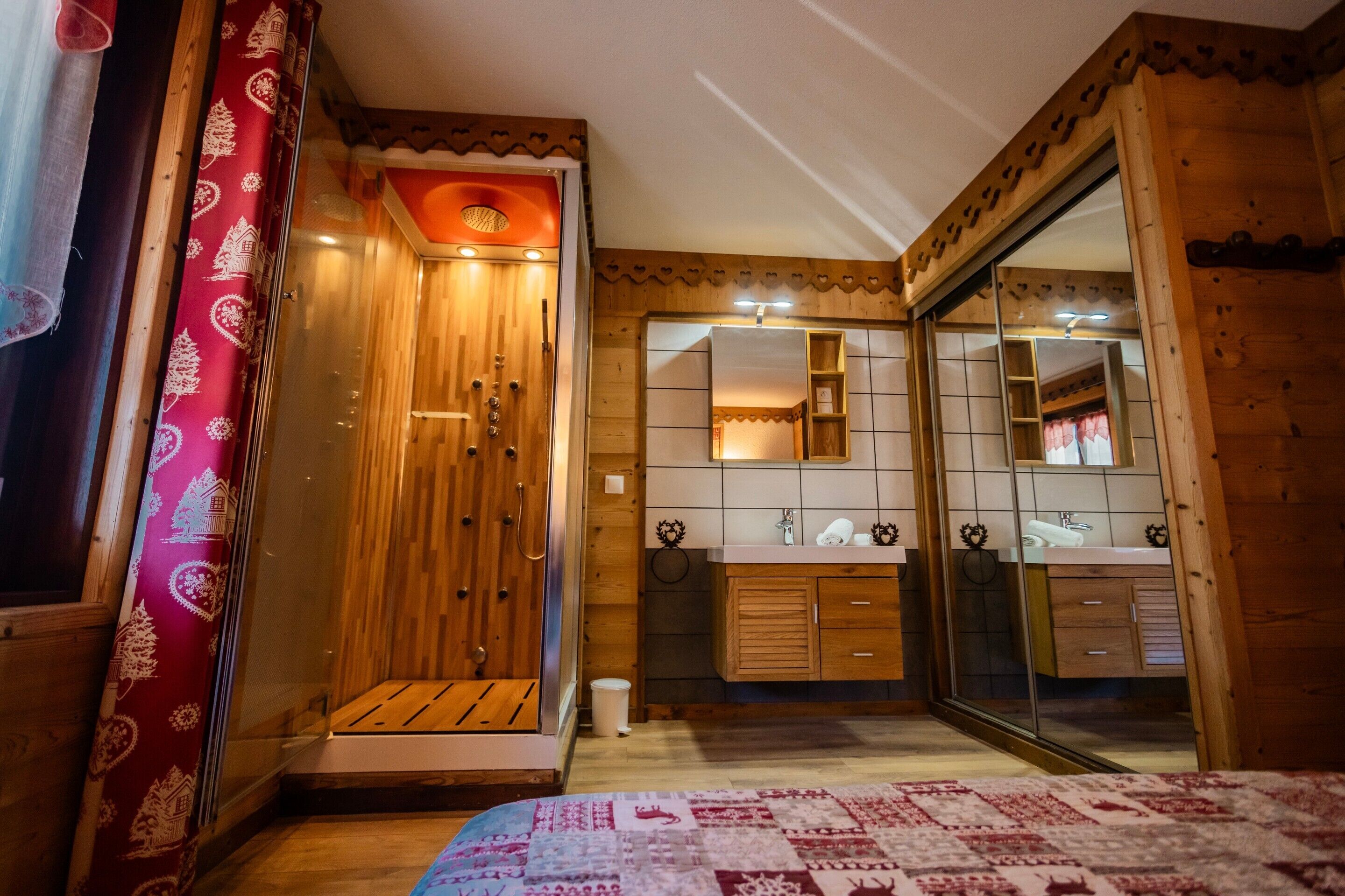 A wooden room with a bed, a wooden cabinet, a mirror, and a sliding door.