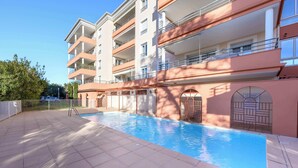 A multi-story building with a swimming pool, balconies, and a gated entrance. - Le Panama (Saint-Raphaël)