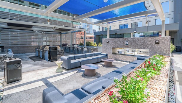 An outdoor patio with seating, a grill, and a view of the city. - Kenect 1310 (Phoenix)