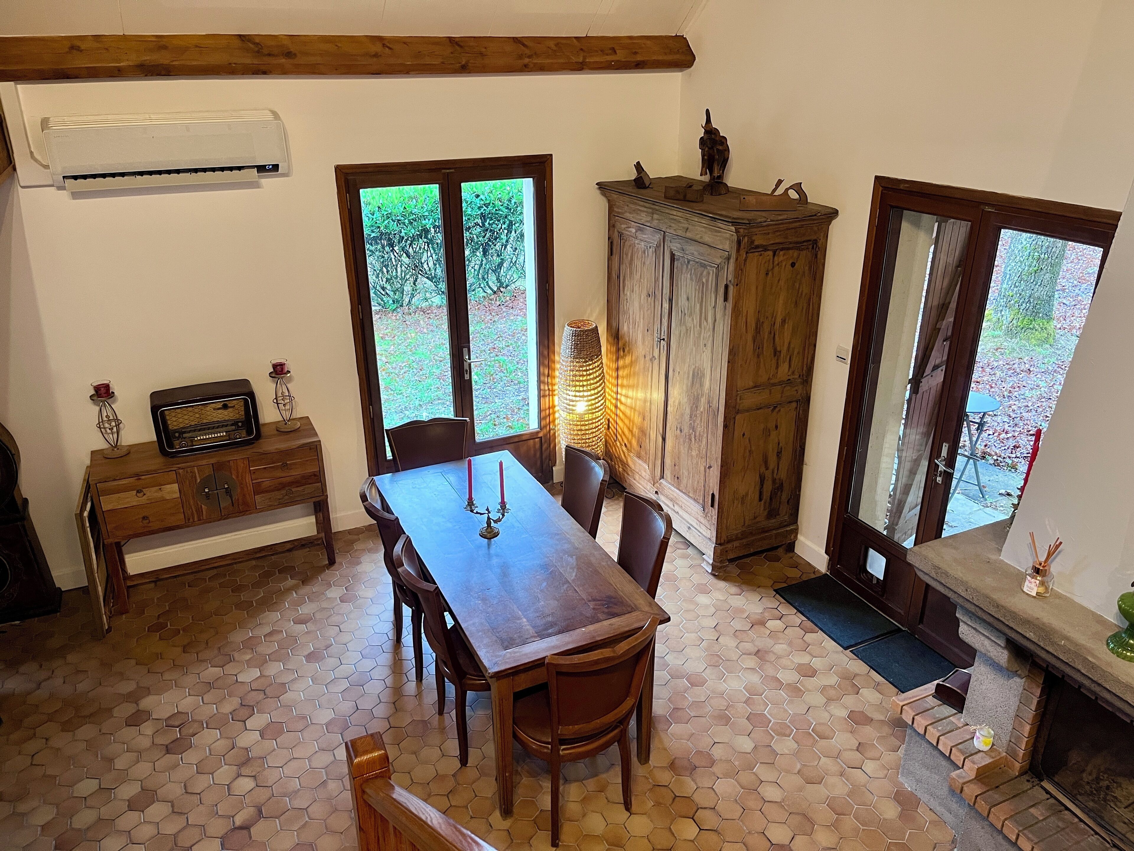 A dining area with a wooden table, chairs, a cabinet, and a fireplace.