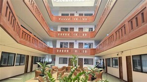 A multi-level atrium with a central seating area, large windows, and a high ceiling. - Collection O Night Bazaar Chiangmai (Chiang Mai)