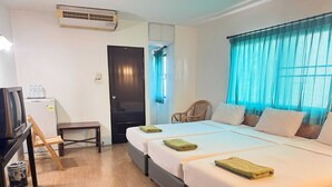 A hotel room with a bed, a desk, a chair, and an air conditioning unit. - Collection O Night Bazaar Chiangmai (Chiang Mai)