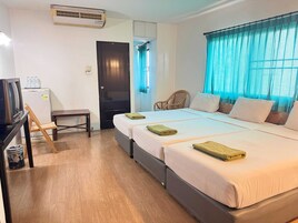 Habitación de hotel con cama, escritorio, silla y unidad de aire acondicionado.