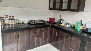Une cuisine moderne avec des meubles en bois foncé, un plan de travail noir et un dosseret de carrelage blanc.