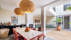 Una cocina moderna con una isla central, sillas rojas y una lámpara colgante grande de fibras naturales.