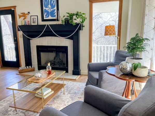 A living room with a fireplace, a sofa, a coffee table, and a side table with decorative items.