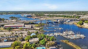 Un puerto deportivo con barcos amarrados, un puente y edificios industriales.