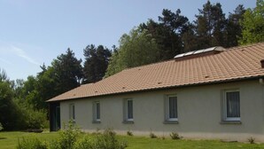 A single-story building with a tiled roof, a flat facade, and a small front garden. - hôtel le grand chêne (Gièvres)