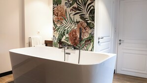 A modern bathroom with a freestanding bathtub, a showerhead, and a decorative floral wall panel. - 5 chambres en ville (Clermont-Ferrand)