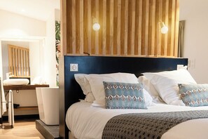 A modern hotel room with a large bed, a wooden headboard, and a bedside table with a lamp. - 5 chambres en ville (Clermont-Ferrand)