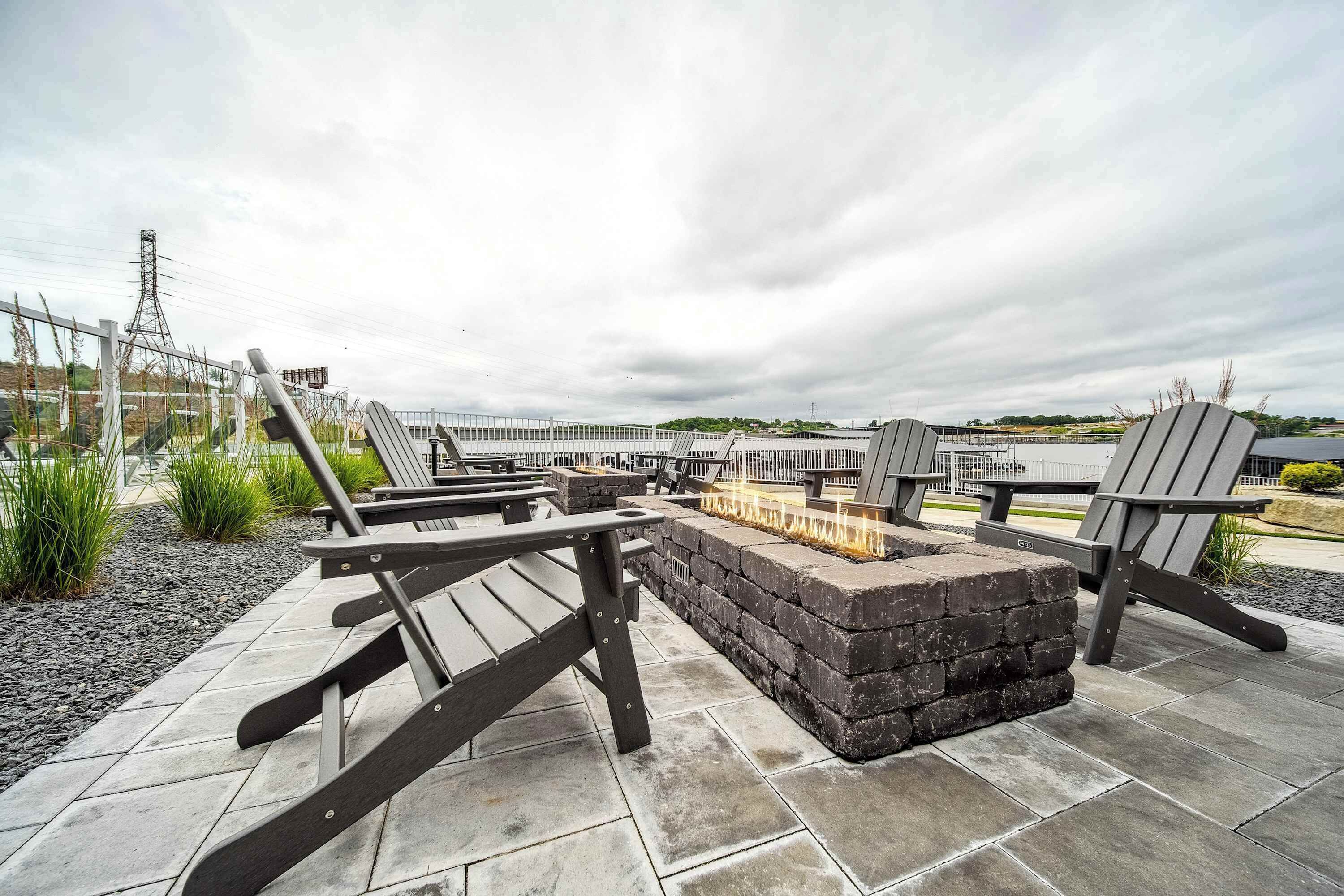 An outdoor seating area with Adirondack chairs and a fire pit.