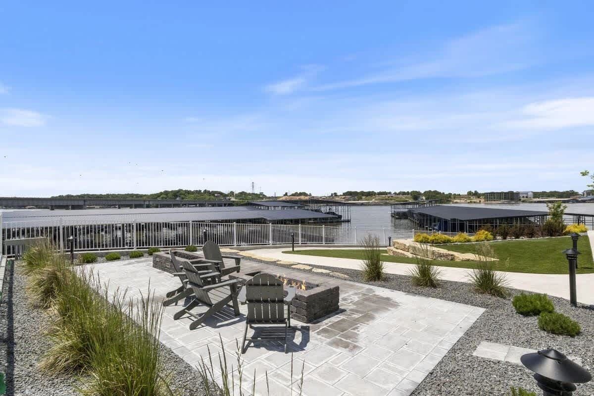 A patio area with outdoor seating and a view of a body of water.