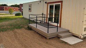 Una casa móvil de un piso con un porche delantero y una pequeña terraza.