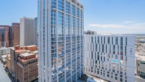 A modern high-rise building with a glass facade, surrounded by other high-rise buildings in an urban setting. - Kenect 1816 (Phoenix)