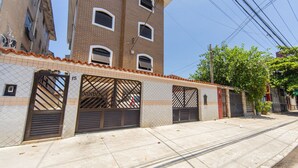 Un bâtiment à la façade recouverte de tuiles, doté de plusieurs portes de garage et surplombant un ciel dégagé.