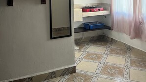 A bathroom with a mirror, a shelf with toiletries, a sink with a pink radio, and a shower curtain. - HOSTAL MID GY (Mérida)