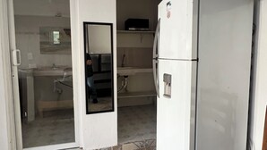 A kitchen with a refrigerator, a sink, and a tiled floor. - HOSTAL MID GY (Mérida)