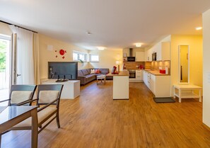 A modern apartment with a living room, dining area, and kitchen.