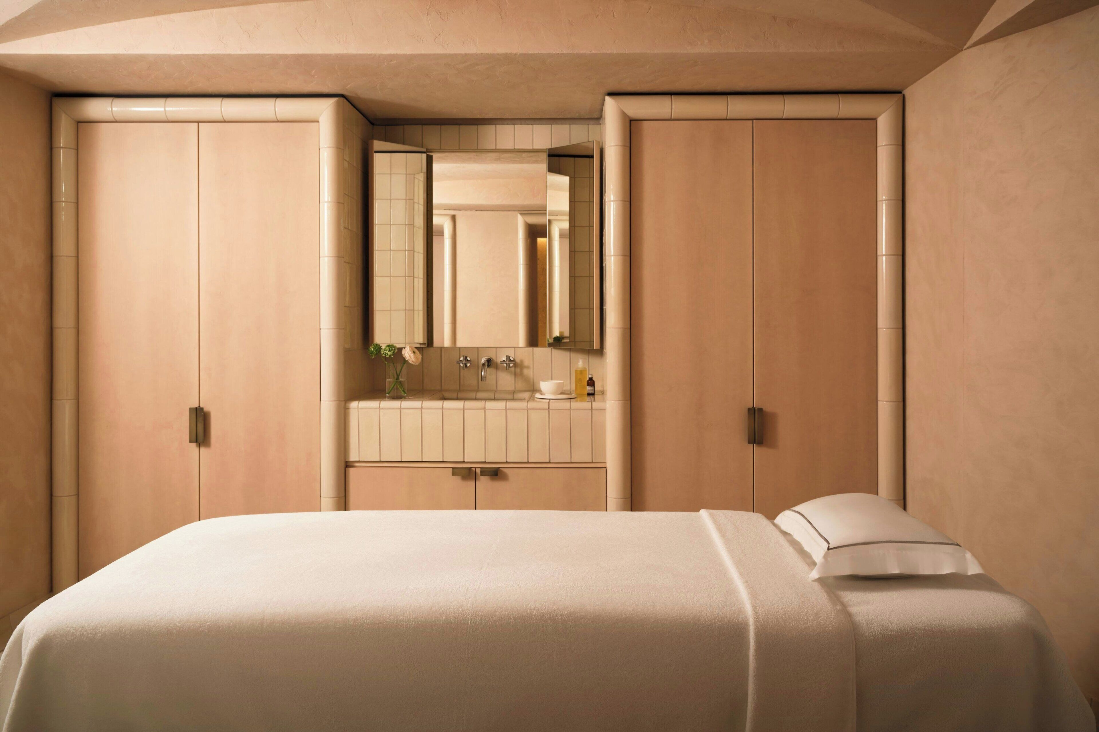 Una camera da letto con un letto grande, un bagno con uno specchio e un armadio.