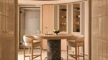 A modern interior with a round table, two chairs, and a marble base.