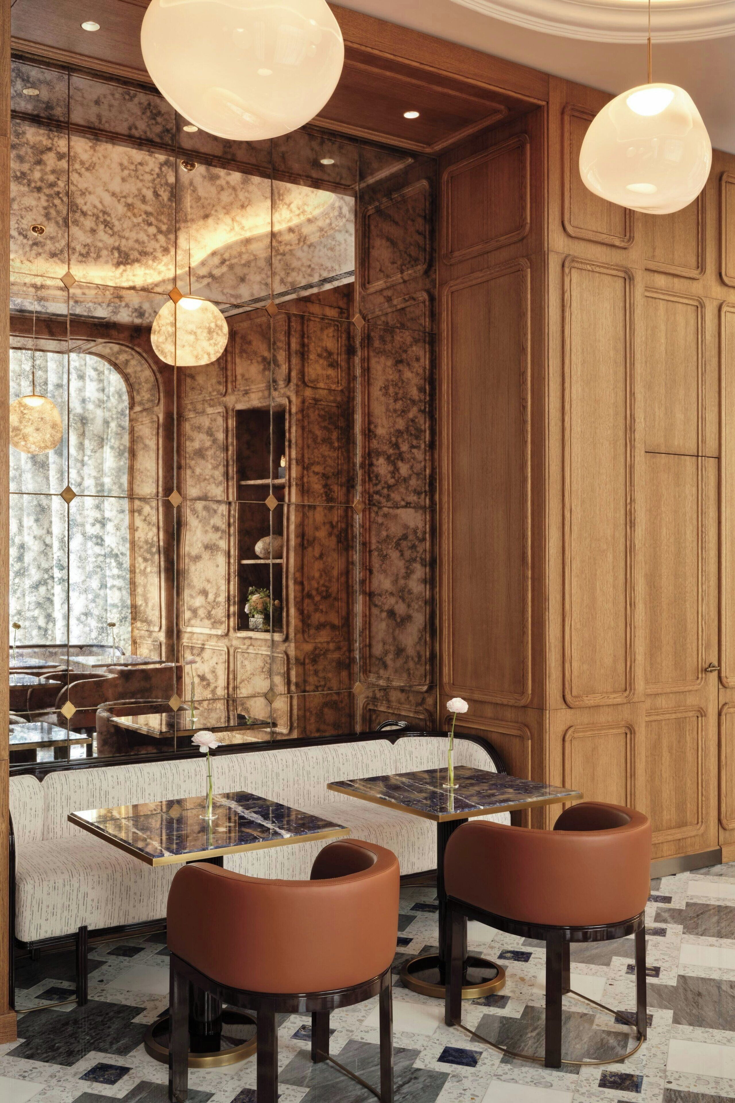 A restaurant with marble walls, wooden paneling, and pendant lighting.