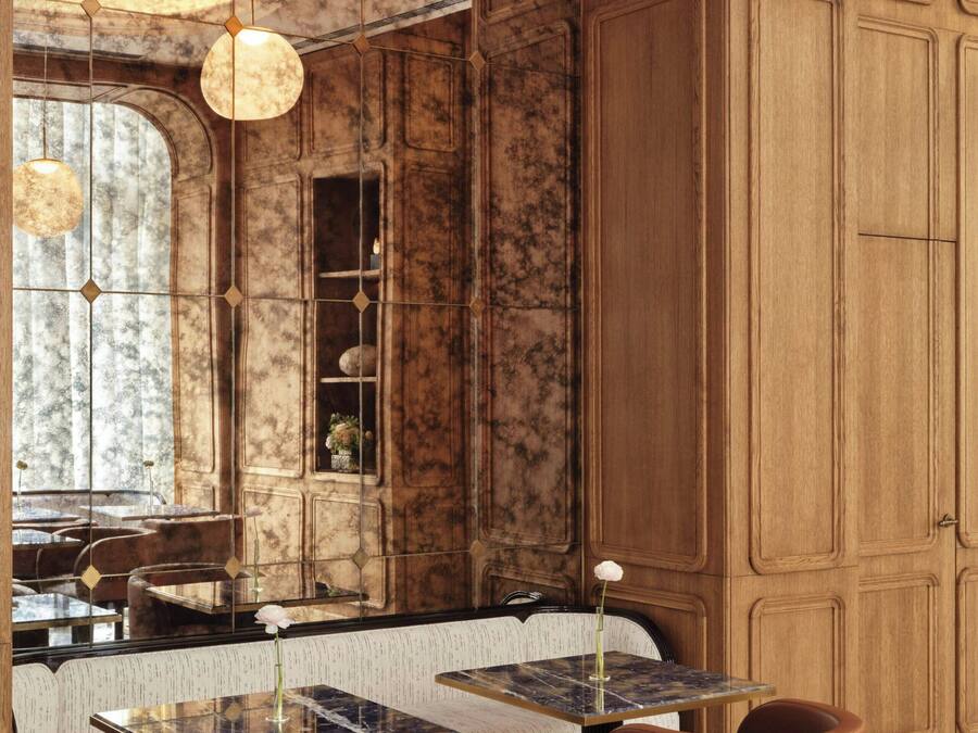 A restaurant with marble walls, wooden paneling, and pendant lighting.