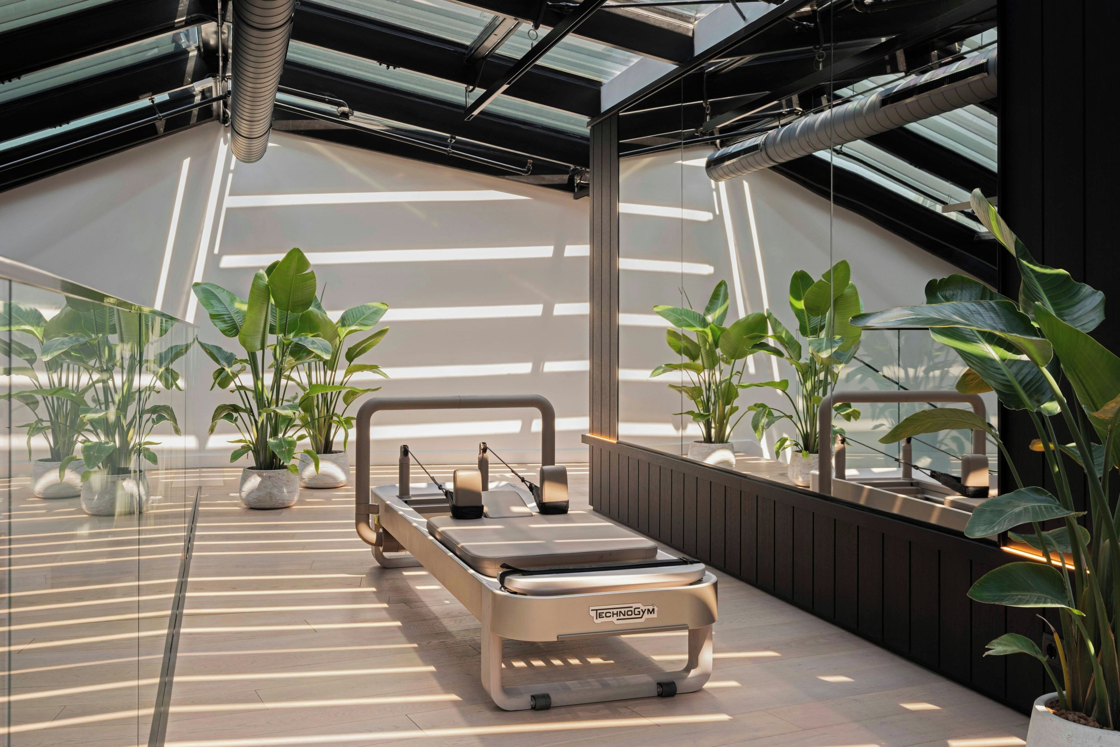 Un gimnasio moderno con diseño minimalista, que cuenta con una barra de dominadas y un banco.