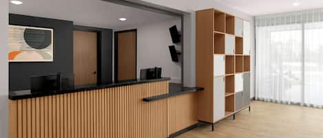 A reception area with a wooden reception desk, a black countertop, and a wall-mounted TV. There is a large window with sheer curtains and a wooden bookshelf to the right.